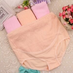 Two maternity panties in pink and peach laying on a lace background.
