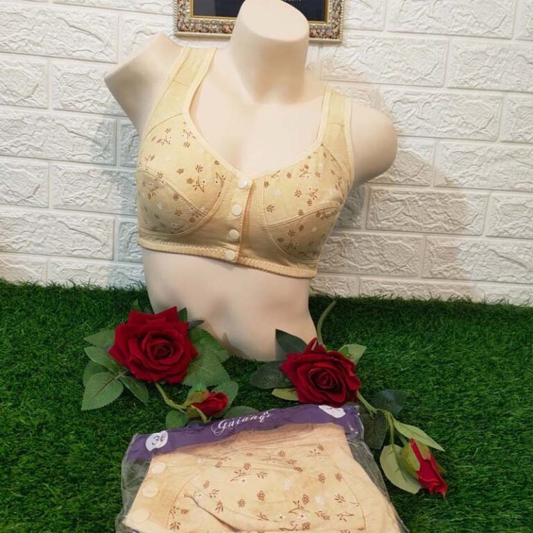 A beige bra displayed on a mannequin, surrounded by red roses on green grass-like fabric.
