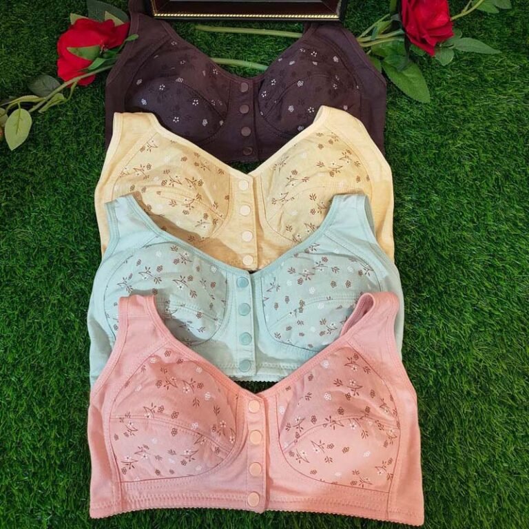 A collection of four different colored bras displayed on a grassy background.