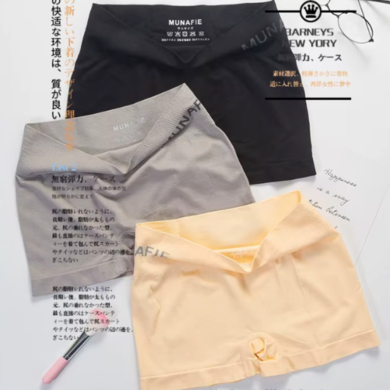 Three pairs of women's shorts in black, gray, and yellow laid out on a flat surface with some additional text and a pen.