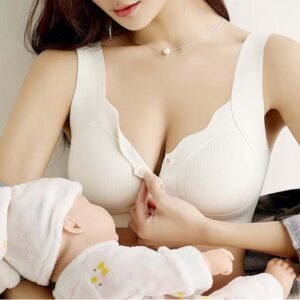 A woman wearing a white nursing bra, demonstrating its functionality while holding a baby doll.
