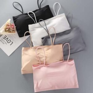 A collection of six seamless cami tube bras in various colors including black, white, gray, beige, and pink, displayed on a gray surface alongside a bouquet of flowers and a magazine.